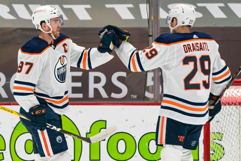 Connor McDavid (97) of the Edmonton Oilers celebrates with teammate Leon Draisaitl (29) after scoring a goal against the Vancouver Canucks at Rogers Arena on May 3, 2021.