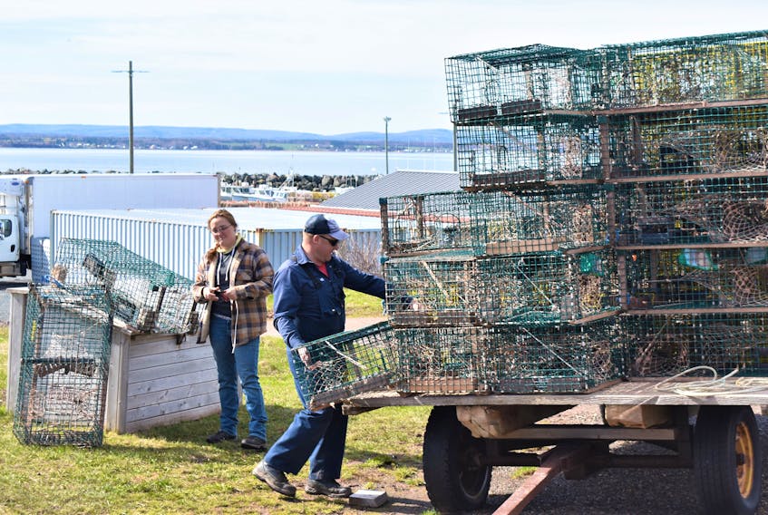 Hailey Scotland and Robert Heighton Jr. loading traps as part of work for the Ocean Rider 1 lobster boat which fishes from off the Cape John Wharf. 