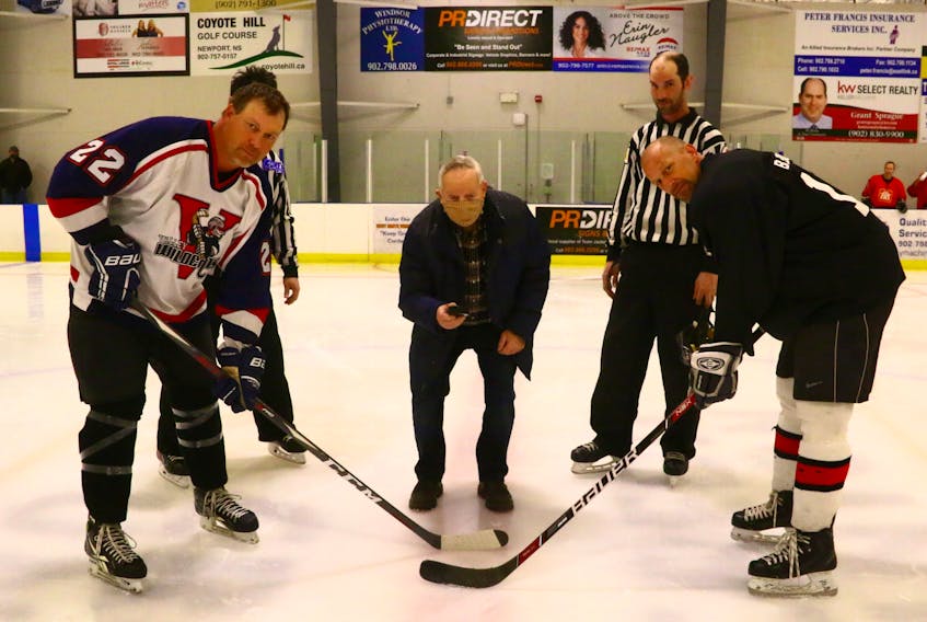 Robin Lowthers, left, and Bradley Burgess were at the ready as Wayne Lunn, brother of the late Gary Lunn, prepared for the ceremonial puck drop at a special exhibition game in April. 
JIM IVEY

