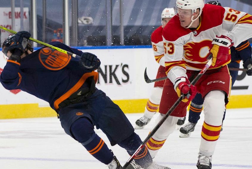  Edmonton Oilers forward Gaetan Haas is upended by Calgary Flames forward Buddy Robinson during third-period NHL action on Saturday, May 1, 2021 at Rogers Place.