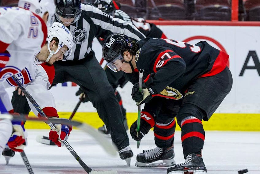 Ottawa Senators centre Shane Pinto (57) wins the draw cleanly against Montreal Canadiens centre Nick Suzuki (14).