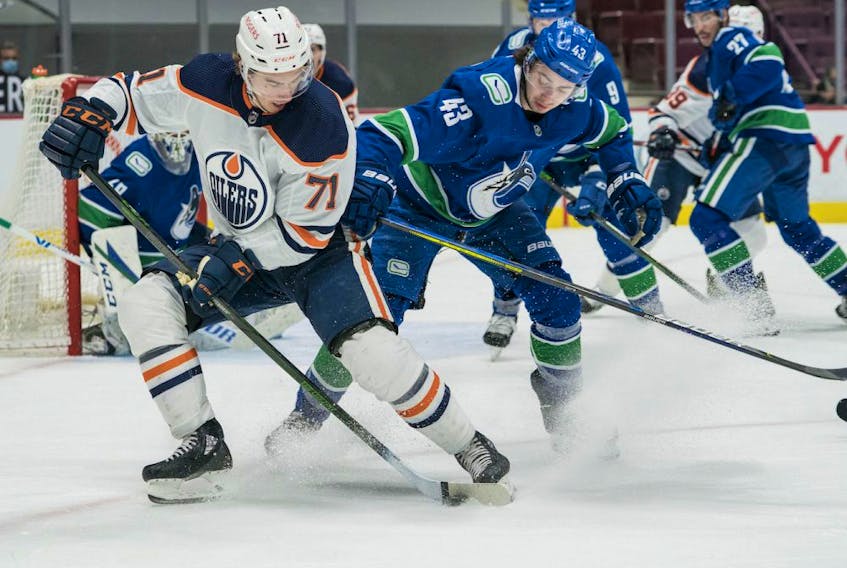 Vancouver Canucks defenseman Quinn Hughes (43) checks Edmonton Oilers forward Ryan McLeod (71) in the third period at Rogers Arena. Oilers won 5-3 on May 4, 2021. 