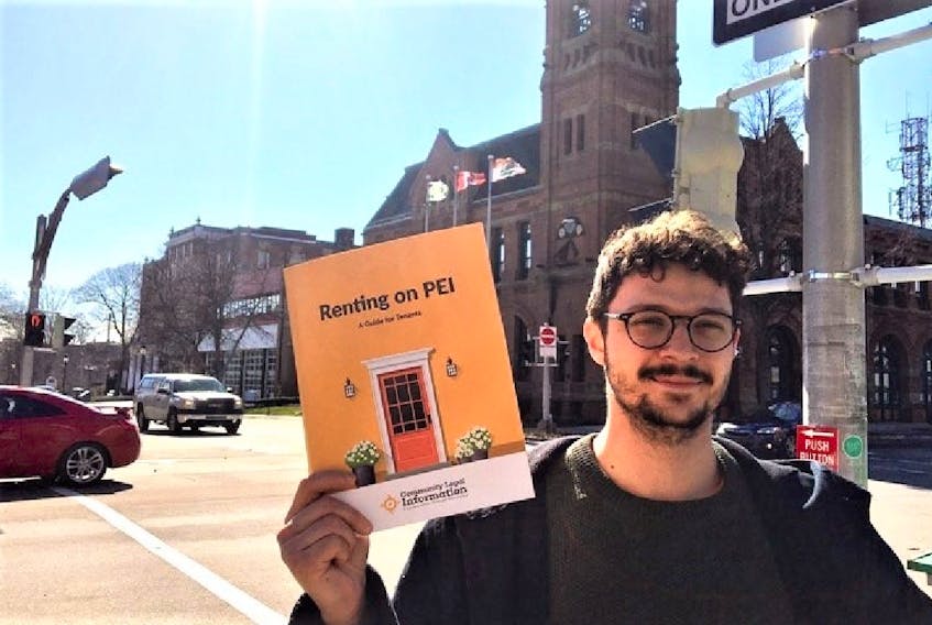 David McQuillan, 27, holds up a copy of the free handbook on tenants' rights. Copies are available at the public library. 