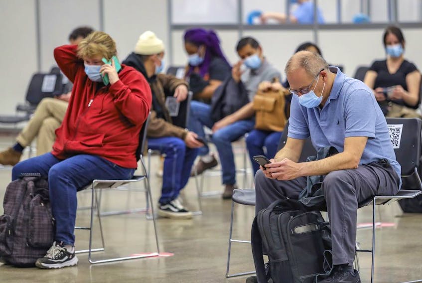 People sit in the post-vaccination waiting area at the COVID-19 vaccination clinic at the Palais des congrés in Montreal Tuesday May 4, 2021. 