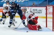  Blake Wheeler of the Jets battles for a puck with Artem Zub of the Senators in front of netminder Filip Gustavsson during second-period play.