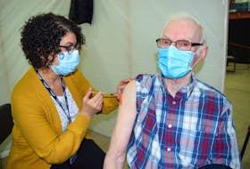 Dougie Gouthro, 84, of Gardiner Mines, happily receiving his first dose of the Pfizer-BioNtech vaccine from Claudia AuCoin, an LPN with Public Health, at the Canada Games Complex at Cape Breton University in Sydney on March 10. Vaccinations rolled out in early March for Nova Scotians ages 80 and older. Sharon Montgomery-Dupe/Cape Breton Post