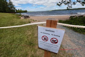 A warning sign and a red fire tape is all that’s left after Halifax Fire and Emergency comb the waterfront along Grand Lake to take test samples of the water. Since officials aren’t sure what the source of the water issues are, no access for the media is possible.