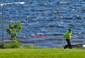 FOR NEWS STORY:
A parks employee puts up caution tape across the beach at Oakfield Park in Grand Lake....the lake is now closed to all boating, fishing, swimming etc....for CAMPBELL STORY.