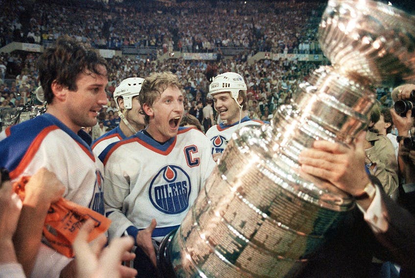 Oilers captain Wayne Gretzky and Paul Coffey get ready to hoist the Stanley Cup during the presentation in Edmonton on May 31, 1985.