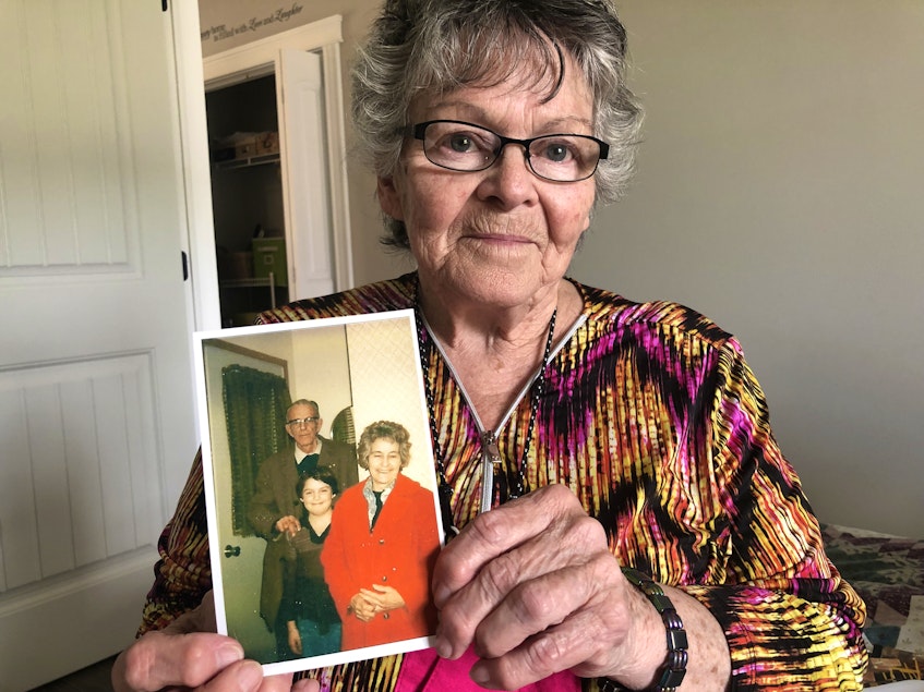 Marie Sonier holds a photo of her father, mother and youngest child. - Kristin Gardiner