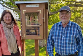 Gail Snowden, left, and her husband, Ewing, next to the tiny library they built for their community.