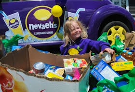 Nevaeh’s cousin two-year-old Juliana Denine, also got in on the action at the unveiling on Saturday afternoon as she sits by Nevaeh’s Lemonade Stand car, a Volkswagon Beetle, as she enjoys sorting out some of the many many food items donated for the pantry in honour of her cousin Nevaeh.   
-Joe Gibbons/The Telegram
