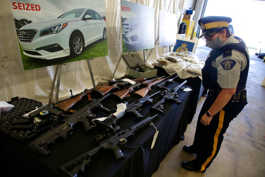 The RCMP's federal serious and organized crime unit has charged 14 people with 100 offences in connection with an 11-month investigation into a drug trafficking ring in Halifax Regional Municipality. Police seized a significant quantity of drugs, firearms and money. Some of the weapons and some of 122 lbs of cannabis products are shown on display at RCMP headquarters in Dartmouth Wednesday.