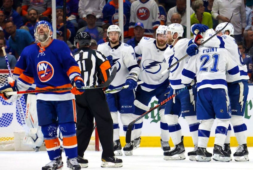 Lightning forward Brayden Point (21) is congratulated by his teammates after scoring a goal as Islanders defenceman Andy Greene (left) reacts during the second period in Game 3 of the Stanley Cup Semifinals at Nassau Coliseum in Uniondale, N.Y., Thursday, June 17, 2021.