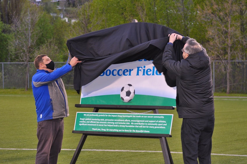 With a toss of the cover the new sign for the Doug Sweetapple Soccer Field on Wellington Street in Corner Brook was unveiled by Mayor Jim Parsons (left) and Sweetapple during a naming ceremony on Tuesday.  - Diane Crocker