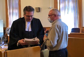 Robin Barrett (right) speaks with his lawyer, Mark Gruchy, after his application hearing in Newfoundland and Labrador Supreme Court Wednesday. Gruchy is arguing for evidence in Barrett's child pornography trial to be thrown out on the grounds that police breached his rights when they questioned him.