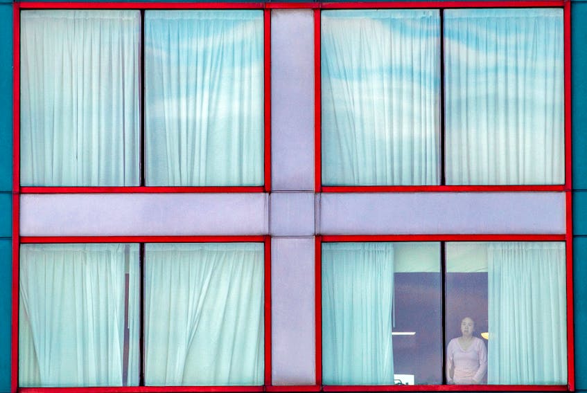  A person looks out of a window at a COVID quarantine hotel in Mississauga, Ont.
