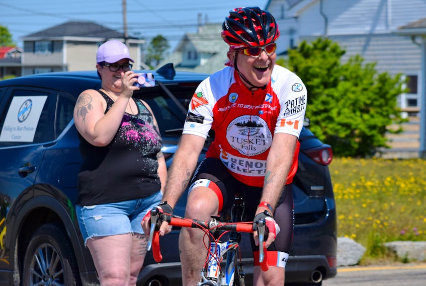 Simon Pont is all smiles as he begins his 1,000-km ride to beat prostate cancer in Clark’s Harbour on June 20. His daughter Rachel captures the moment with her phone. KATHY JOHNSON • TRICOUNTY VANGUARD