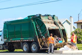 A crew picks up heavy garbage items in front of a home in New Waterford on Monday. IAN NATHANSON • CAPE BRETON POST