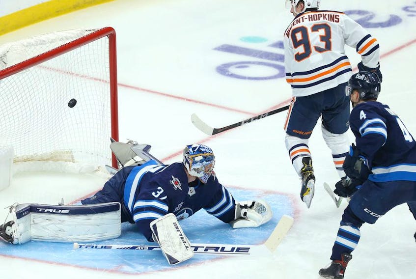 Edmonton Oilers centre Ryan Nugent-Hopkins beats Winnipeg Jets goaltender Connor Hellebuyck during Game 4 of a Stanley Cup playoff series in Winnipeg on Mon., May 24, 2021. 