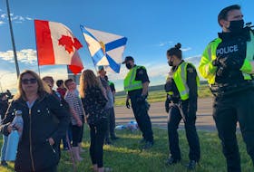 RCMP officers move protesters away from Highway 104 on Wednesday evening ending a blockade at the Nova Scotia border that lasted nearly 24 hours.