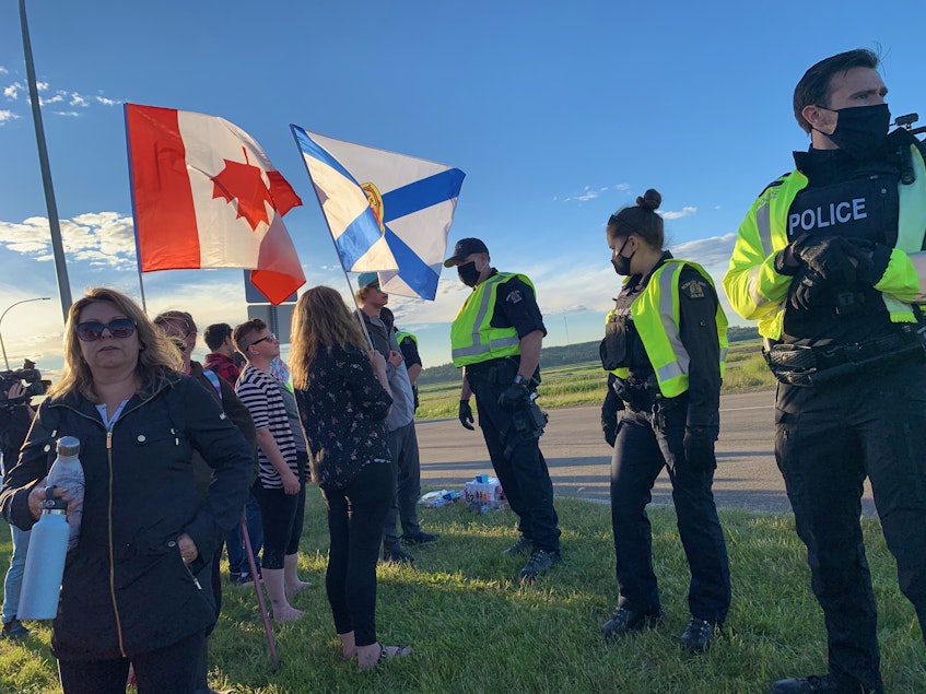 RCMP officers move protesters away from Highway 104 on Wednesday evening ending a blockade at the Nova Scotia border that lasted nearly 24 hours. - Darrell Cole