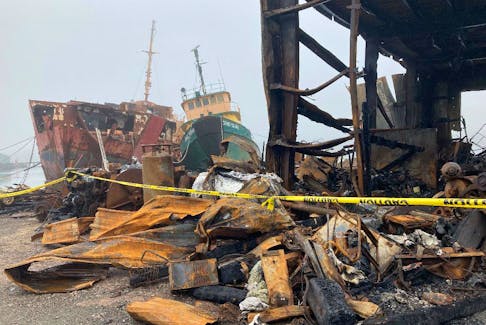 A marine services centre in Marie Joseph burned on June 15. In the background is the former CCGS Sir Charles Tupper, a navigational aids tender that the building's owner, Clem Fleet, had been dismantling.