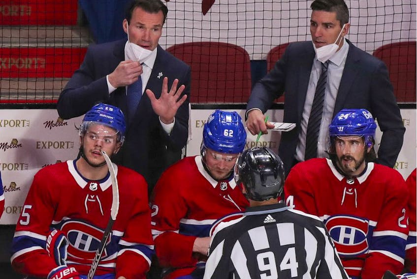 Canadiens assistant coach Luke Richardson speaks with linesman Brian Pancich while fellow assistant coach Alex Burrows looks on from behind bench during Game 3 of Stanley Cup semifinal series against the Vegas Golden Knights at the Bell Centre.