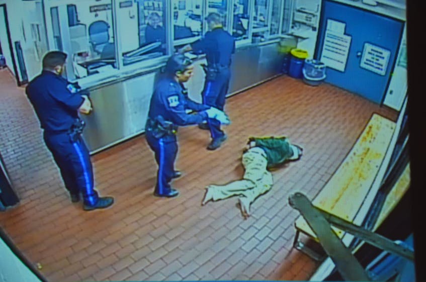 Halifax police constables Justin Murphy, Donna Lee Paris and Ryan Murphy get ready to transport Corey Rogers from the booking area to a cell on the night of June 15, 2016, in this photo taken from a police video. Rogers, who had a spit hood over his head, later died in the cell from asphyxiation. The Nova Scotia Police Review Board is hearing an appeal launched by Rogers' mother, Jeannette, regarding the internal discipline handed out to the three arresting officers. - Contributed
