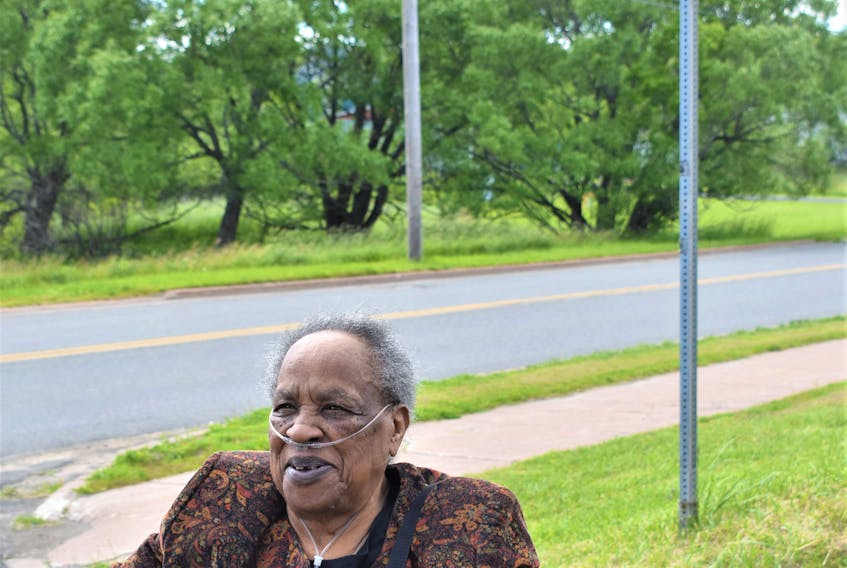 Eighty-six-year-old Phyllis Patterson sits near the new street sign which now reads Reddick Lane. The renaming of Martin Drive honours her family’s legacy in the area, started by her father Joseph Reddick.