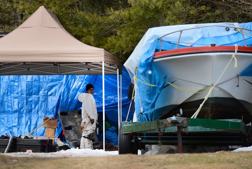 Both the medical examiner and police personnel work at an excavation in the back yard of a Shad Bay home on March 8, 2013. They were searching a property belonging to the brother of Andrew Paul Johnson, a suspect in several Nova Scotia cold case murders who was just denied parole in B.C.