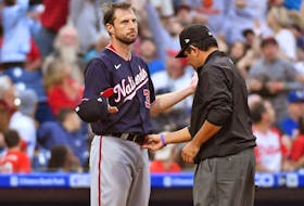Max Scherzer of the Washington Nationals, left, allows the umpire to check his hat and belt for foreign substances. Scherzer was checked three times in four innings for substances and nothing was found. USA TODAY