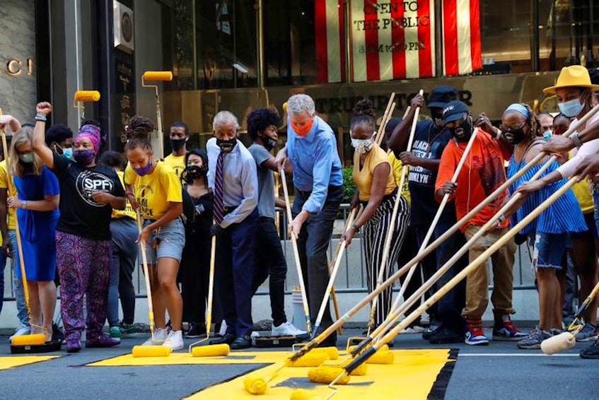 New York City Mayor Bill de Blasio, his wife, Chirlane Irene McCray, and Rev. Al Sharpton paint "Black Lives Matter" along Fifth Avenue with others outside Trump Tower in Manhattan on July 9, 2020. — Reuters file photo