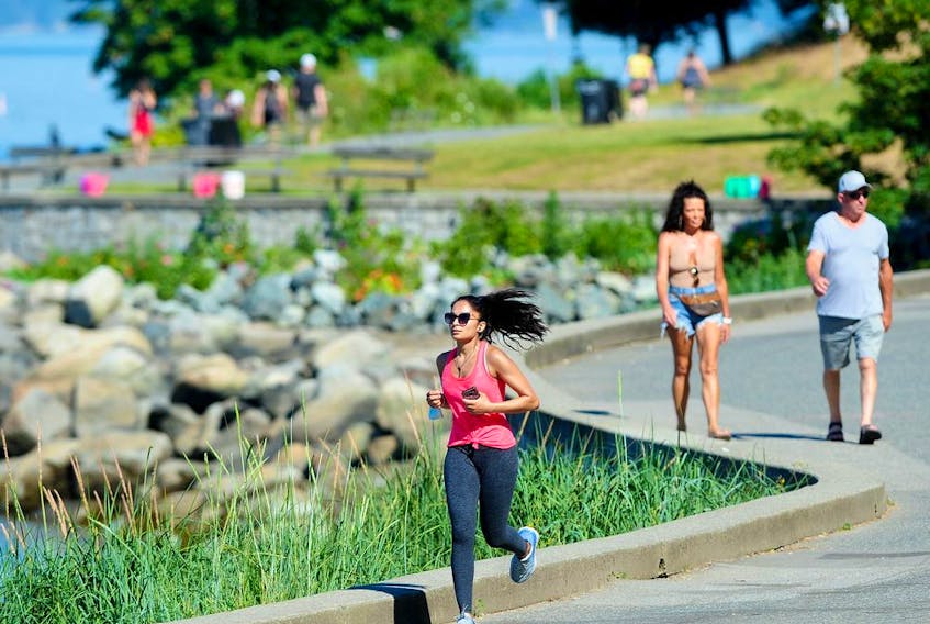 A jogger braves the heat near English Bay in Vancouver on Sunday amid record high temperatures.