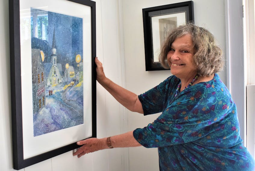 At the Fraser Art Gallery, Joy Laking hangs one of her Great Village paintings she did while spending a week at the Elizabeth Bishop House last winter with fellow artist Susan Paterson.