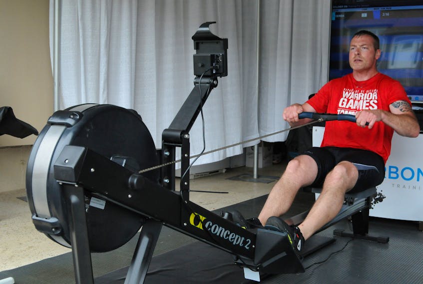 RNC officer Const. Derek McDonald goes about his strokes on his ergometer rowing machine in his home garage as supporter rowers went about their strokes on ergometers set-up on his driveway.