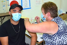 Joran Hart, 26, of Glace Bay, a correctional officer at the Cape Breton Correctional facility, gets vaccinated by Debbie Roach of Sydney, a nurse practitioner, at the clinic at the Canada Games Complex at Cape Breton University, Tuesday. The Department of Health and Wellness said Nova Scotia is doing well with 72.4 percent receiving one dose or more but there’s a serious concern with the lack of young men ages 20-30 getting vaccinated.