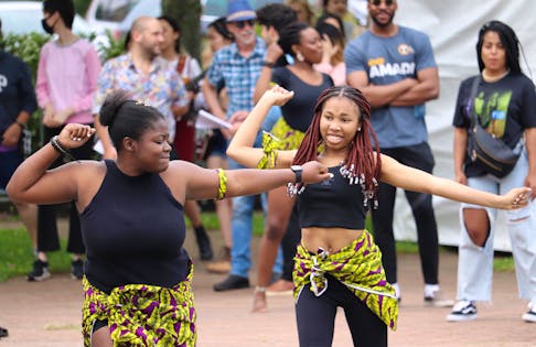 Chinwe Okwuwolu, left, and Vanessa Kuku perform as the Fela Ladies dance group at the DiverseCity Festival in Charlottetown. Member Shalom Nnadi can be seen in the background beside founding member Daniel Ohaegbu.