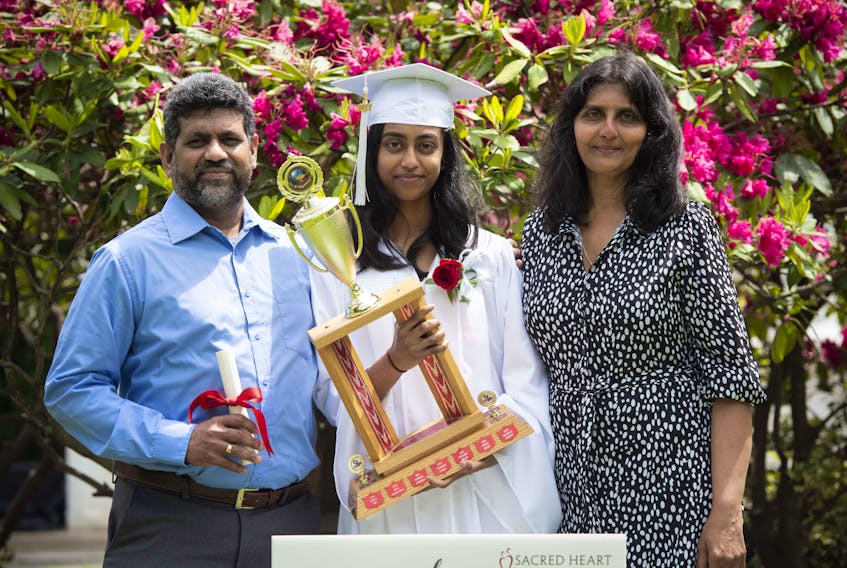 “We’re extremely proud of our daughter,” says Arunika Gunawardena (right), pictured with her husband, Rajesh Rajaselvam (left), as they celebrate their daughter Anisha’s graduation from Sacred Heart School of Halifax. - Photo Contributed.