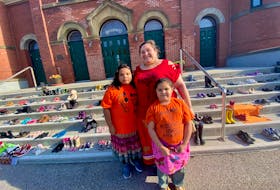 With her daughters Shirley, 8, and Norah, 5, Stephanie Tuplin stands in front of St. Ambrose Cathedral in Yarmouth where a memorial of children’s shoes were laid out after the discovery of the remains of up to 215 children buried in an unmarked mass grave on the site of a former Kamloops, BC, Indian Residential School. While the circumstances are heartbreaking, Tuplin said she was proud to raise awareness with her daughters. TINA COMEAU • TRICOUNTY VANGUARD

