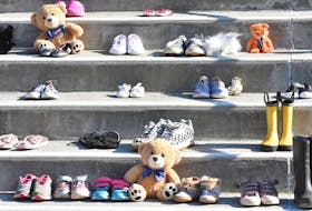 Shoes and boots of all sizes sit on the steps of St. Ambrose Cathedral in remembrance and honour of the up to 215 children found buried at a former Indian Residential School in Kamloops, BC. TINA COMEAU • TRICOUNTY VANGUARD

