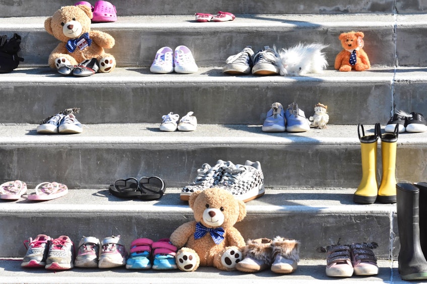 Shoes and boots of all sizes sit on the steps of St. Ambrose Cathedral in remembrance and honour of the up to 215 children found buried at a former Indian Residential School in Kamloops, BC. - Tina Comeau