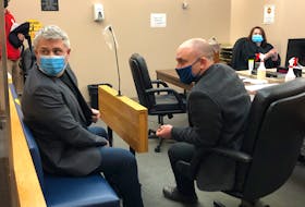 Kurt Churchill (left, in blue mask) sits in Provincial Court in St. John's with his lawyer, Robby Ash. Last year, Churchill was found guilty of threatening a police officer.