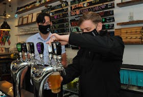 Premier Andrew Furey (right) pours himself a pint of Iceberg beer at Quidi Vidi Brewery in St. John’s on Friday as the brewery’s sales and marketing director, Justin Fong, looks on. Joe Gibbons • The Telegram