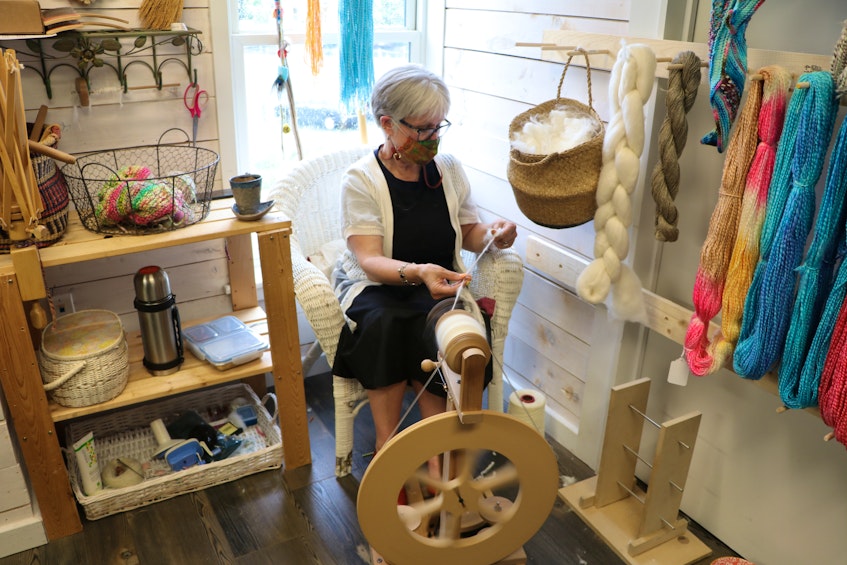 Beth Howley, who owns Angoraborealis in the Quidi Vidi Village Plantation, spins Angora rabbit hair into wool Friday. Howley knits high-end shawls and other products. — Glen Whiffen/The Telegram