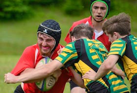 Ivan Kimpinski, left, of the Charlottetown Rural Raiders takes on two Three Oaks Axemen defenders Saturday during the gold medal game of the Prince Edward Island School Athletic Association senior AAA boys rugby season.