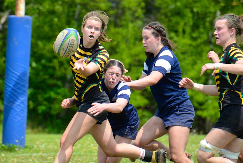 Paige MacLean, left, offloads the ball to a Three Oaks teammate before being tackled by a Bluefield Bobcat during the the Prince Edward Island School Athletic Association senior AAA girls rugby championship Saturday in Hampshire.