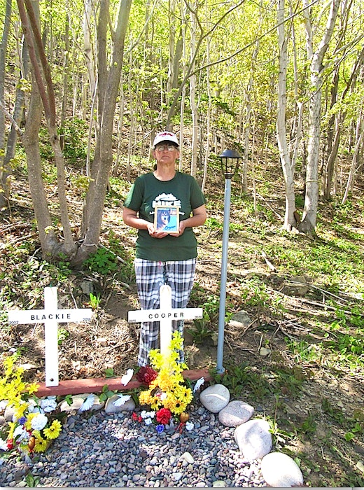 Arlene Fougere of Meat Cove stands by the gravesite of her husky Cooper. Her dog was mistakenly euthanized last August at a Highland Animal Hospital clinic in Ingonish. CONTRIBUTED