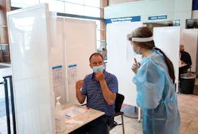 FOR PEDDLE STORY:
Health staff member gives some instructions to an air passenger before they were to conduct their self-administered throat swab test in the arrivals area at Halifax Stanfield Airport Tuesday Jun8, 2021. 

TIM KROCHAK PHOTO