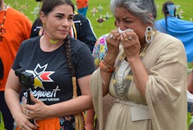 Laurianne MacMillan, right, a Cree woman, is overcome with emotion during a ceremony Tuesday at the Abegweit First Nation in Scotchford to remember the 215 children whose remains were discovered last month in Kamloops, B.C. Ginger Knockwood, left, a descendant of a residential school survivor, stopped to provide comfort. Dave Stewart • The Guardian